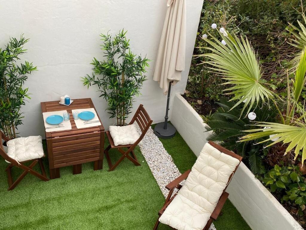 un petit patio avec une table, des chaises et des plantes dans l'établissement Apartamento 315 Castell Sol CB, à Arenal d'en Castell