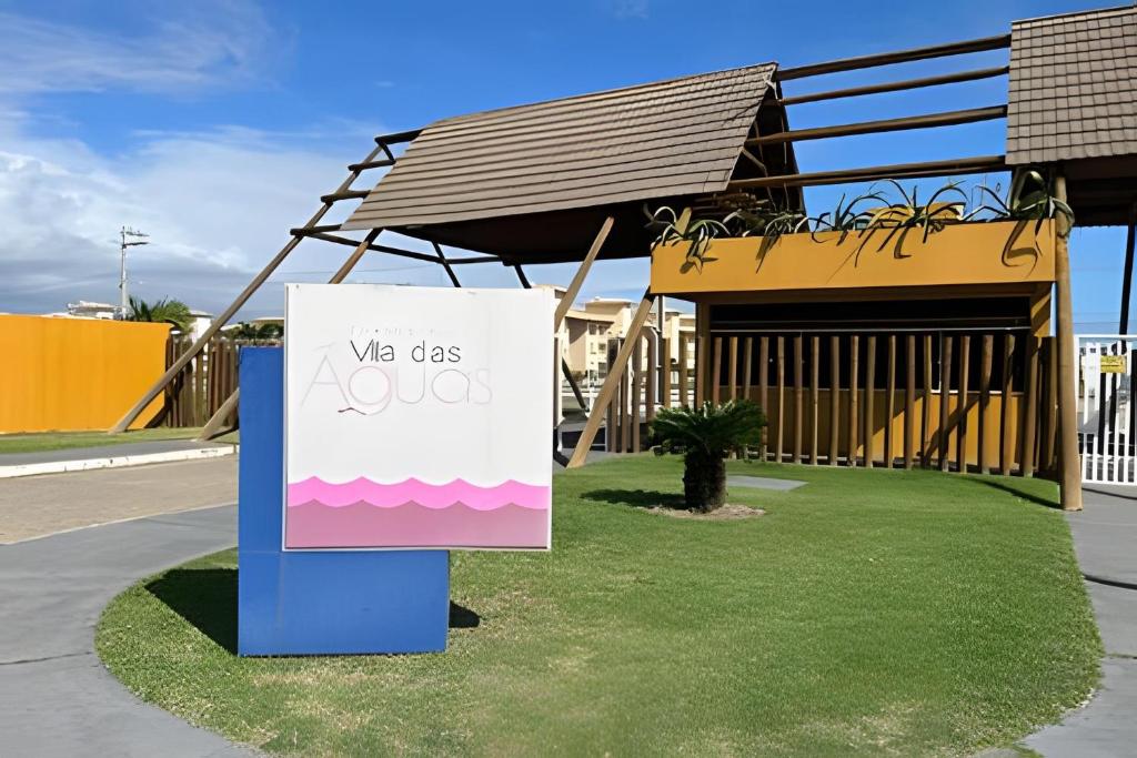 un cartello sull'erba di fronte a un edificio di Condomínio Resort Vila das Águas a Praia do Saco