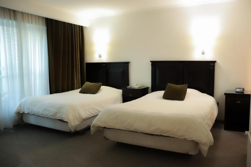 a hotel room with two beds in a room at Hotel Terrano Concepción in Concepción