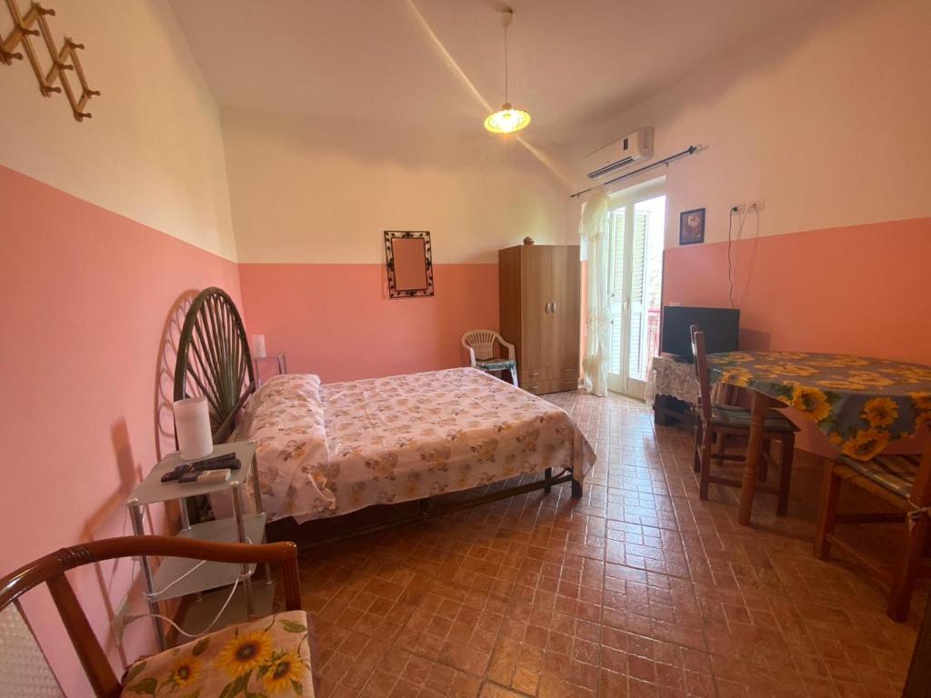 a bedroom with a bed and a table and chairs at Michelangelo's House in Gioiosa Marea