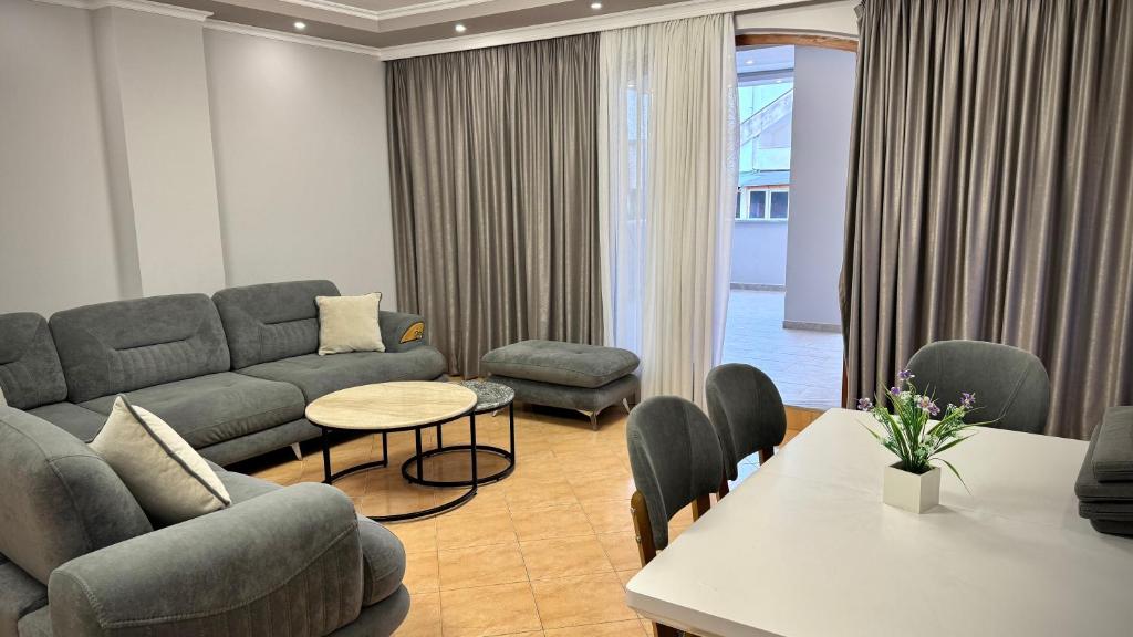 een woonkamer met een bank en een tafel en stoelen bij Sea View Apartments - The Suite in Durrës