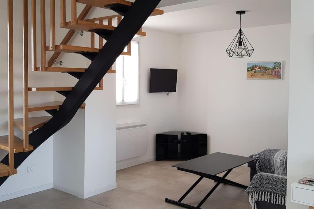 - un salon avec un escalier en colimaçon dans une maison dans l'établissement Maison avec terrasse Classée 3*, à La Brée-les-Bains