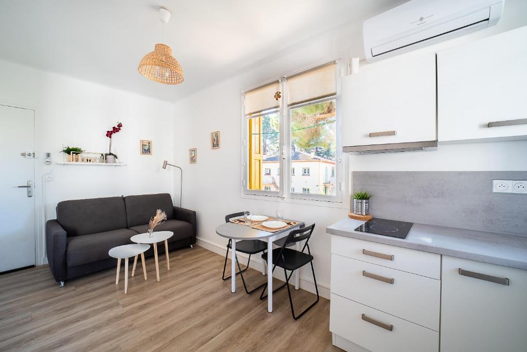 une cuisine et un salon avec un canapé et une table dans l'établissement Petit Bonheur - Appt climatisé proche de la mer, à Argelès-sur-Mer