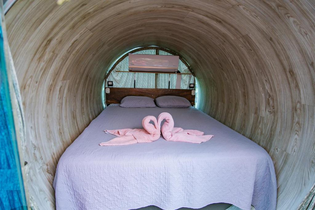 two pink flamingos laying on a bed in a tunnel at Arenal Secret Gardens in Fortuna