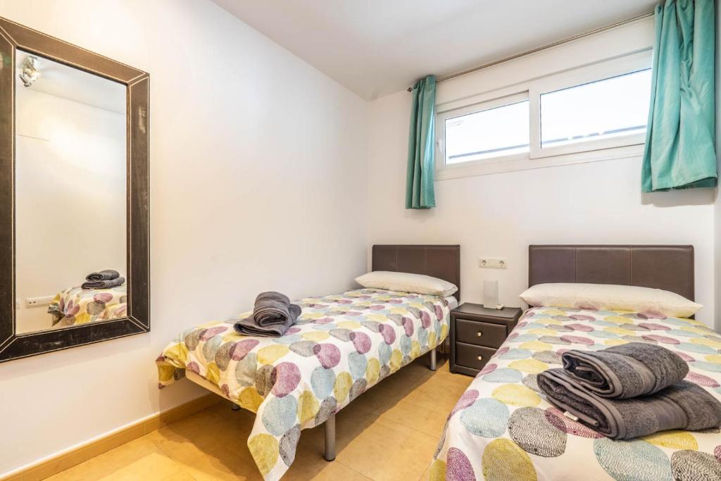 1 Schlafzimmer mit 2 Betten und einem Spiegel in der Unterkunft Casa Naranja, A Simply Spanish Rentals Property in Murcia
