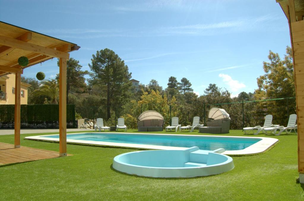einen Pool im Garten mit Stühlen und einem Pavillon in der Unterkunft Villa Paraíso, exclusiva, todas las comodidades in Girona