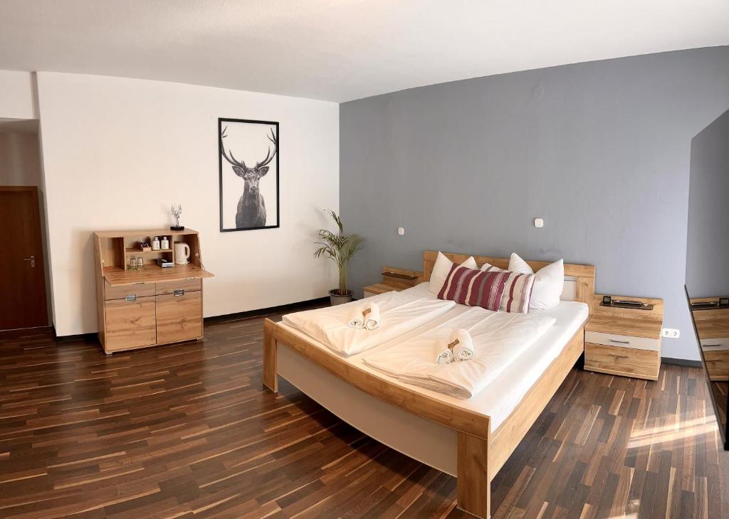 a bedroom with a large bed and wooden floors at Landgasthof Waldeck in Stadtprozelten