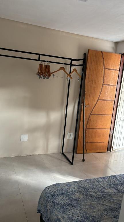 a bedroom with a bed and a wooden door at Kitnet do Mineiro in São José dos Campos