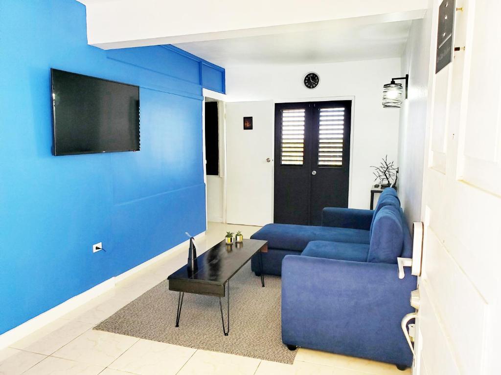a living room with blue walls and a blue couch at the Blue Ackee in Montego Bay