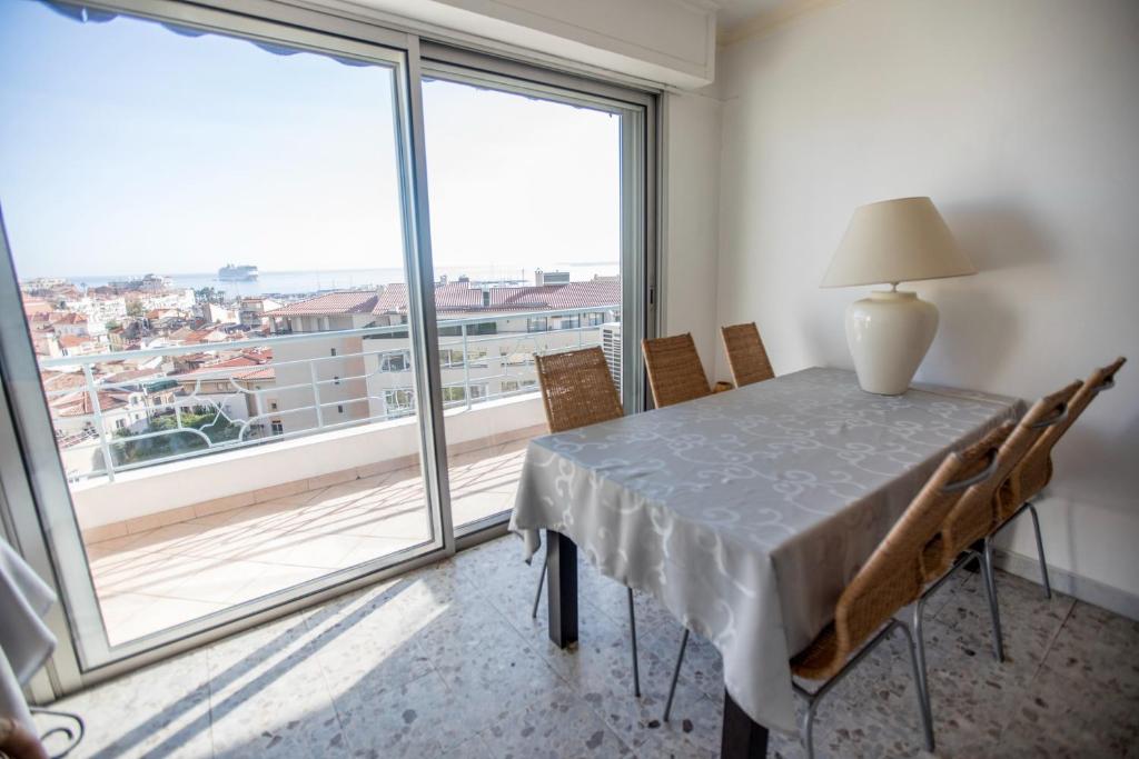 une salle à manger avec une table et une grande fenêtre dans l'établissement Very Nice View by Connexion, à Cannes