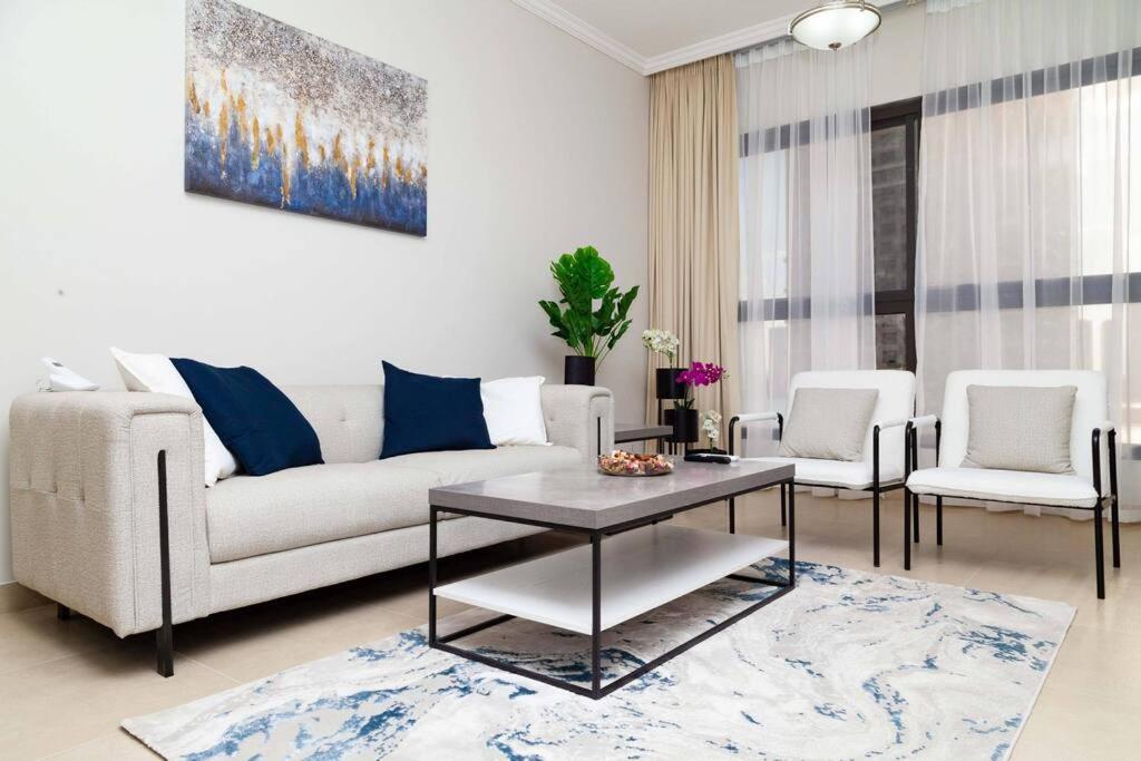 a living room with a couch and a table and chairs at Luxury waterview 2BD in Sharjah