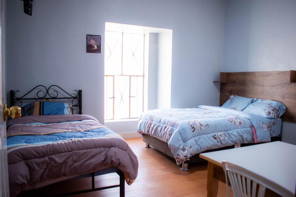 a bedroom with two beds and a window at Hospedaje Tel Aviv in Ayacucho
