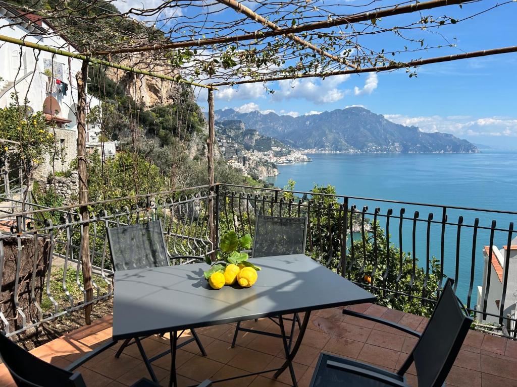 a table with fruit on it with a view of the ocean at Amalfi 51 con vista mare, giardino e terrazze in Conca dei Marini