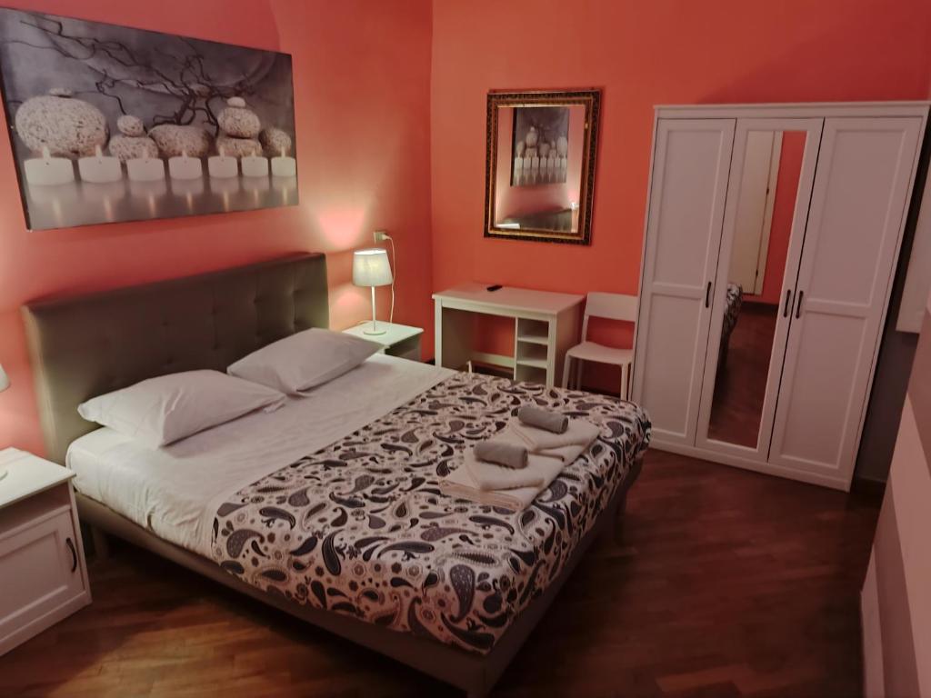 a bedroom with a large bed with orange walls at Albergo Locanda Alambra in Genoa