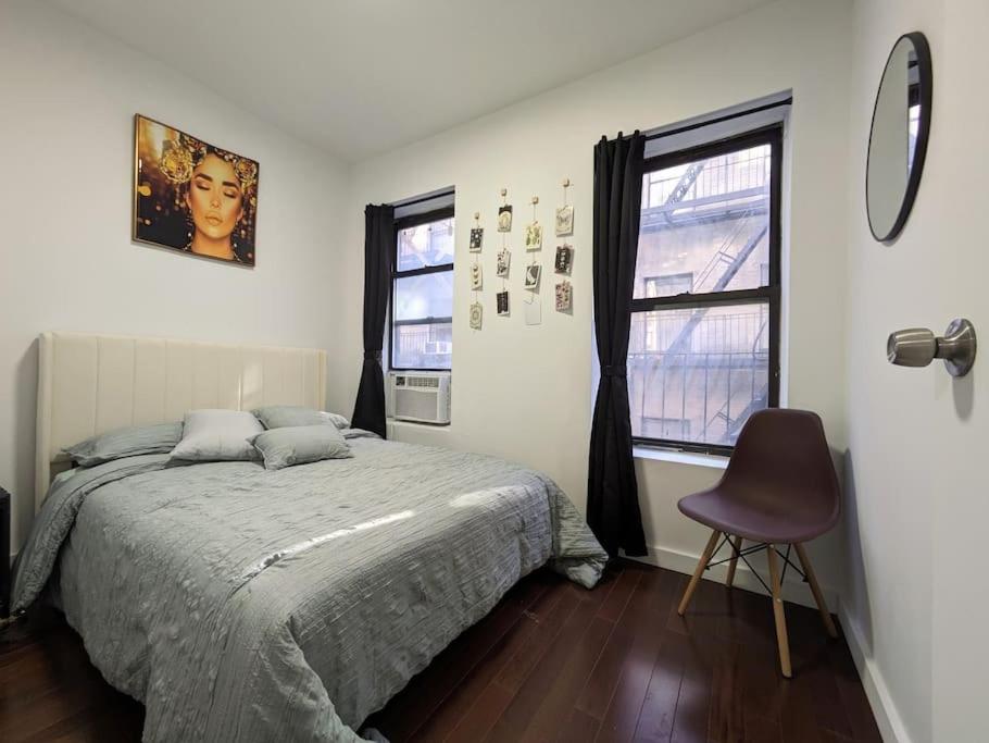 a bedroom with a bed and a chair and a window at Modern One Bedroom in Union Sq - great location in New York