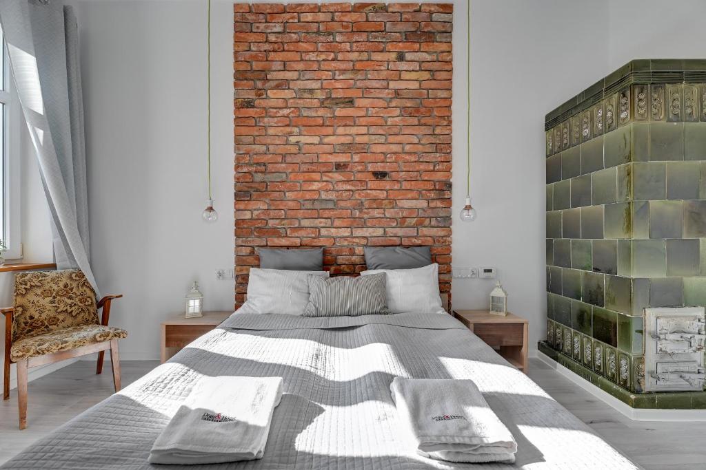 een slaapkamer met een bed en een bakstenen muur bij Dom & House - Apartment Sea Of Mint in Sopot