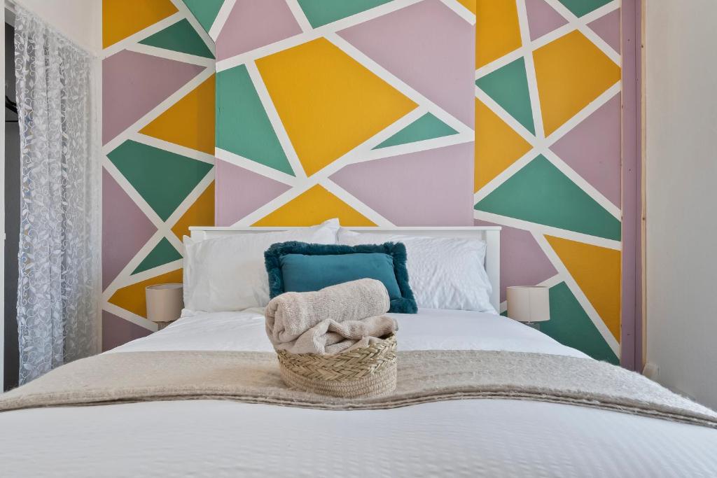 a bedroom with a colorful geometric wall at STAYZED N2 - Modern, Colourful NG7 Home, Next To City Centre, Lots Of Amenities, Ideal for Long & Short Stays. in Nottingham