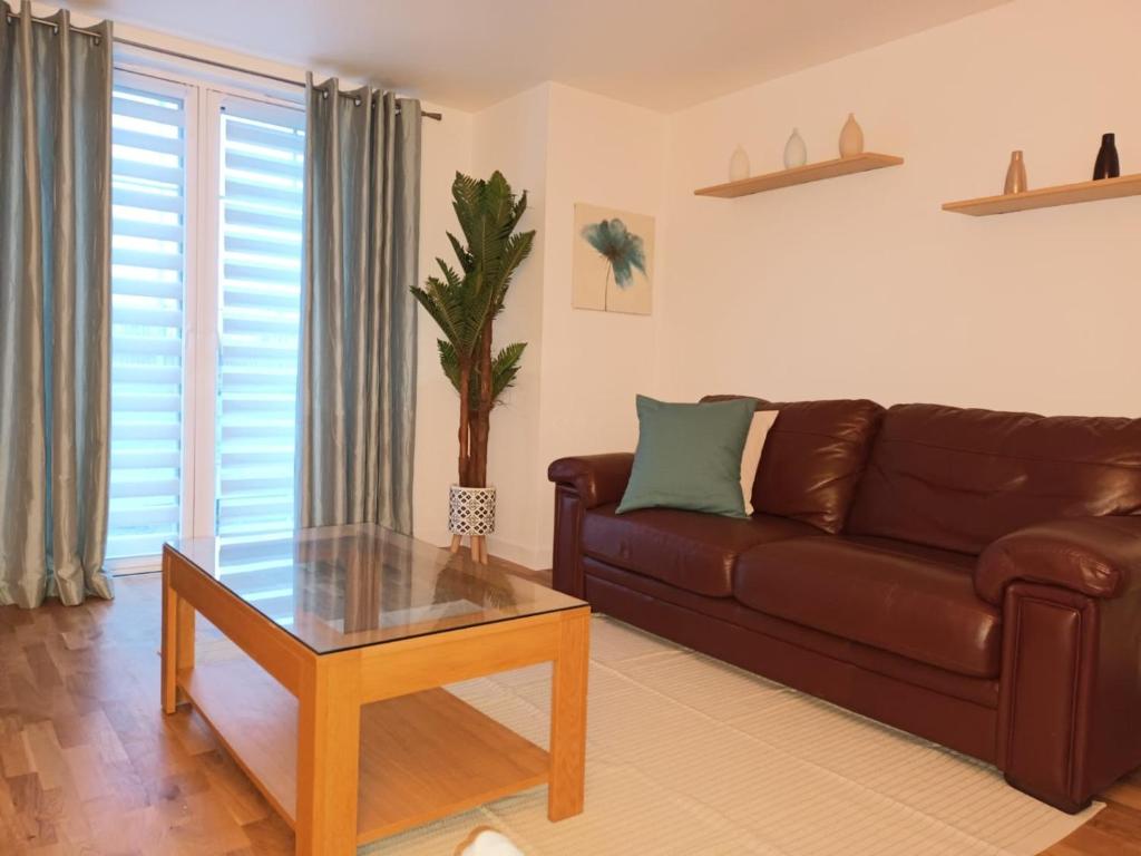 uma sala de estar com um sofá castanho e uma mesa em Spacious Elegant 2-BR Apartment in Aberdeen City Centre em Aberdeen