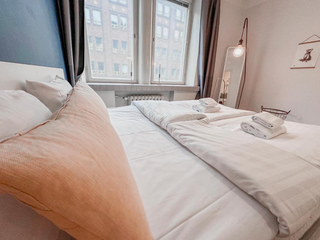 two white beds in a room with a window at Residential Hotels Grand Central in Helsinki