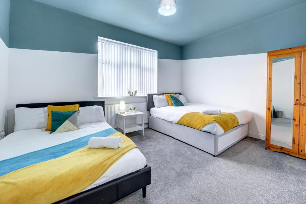 two beds in a room with blue and white walls at Merrivale House in Birmingham