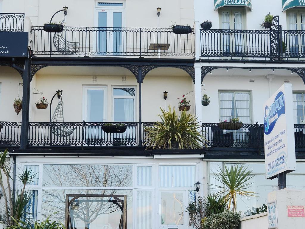 a white building with a balcony and plants on it at Seabreeze in Torquay