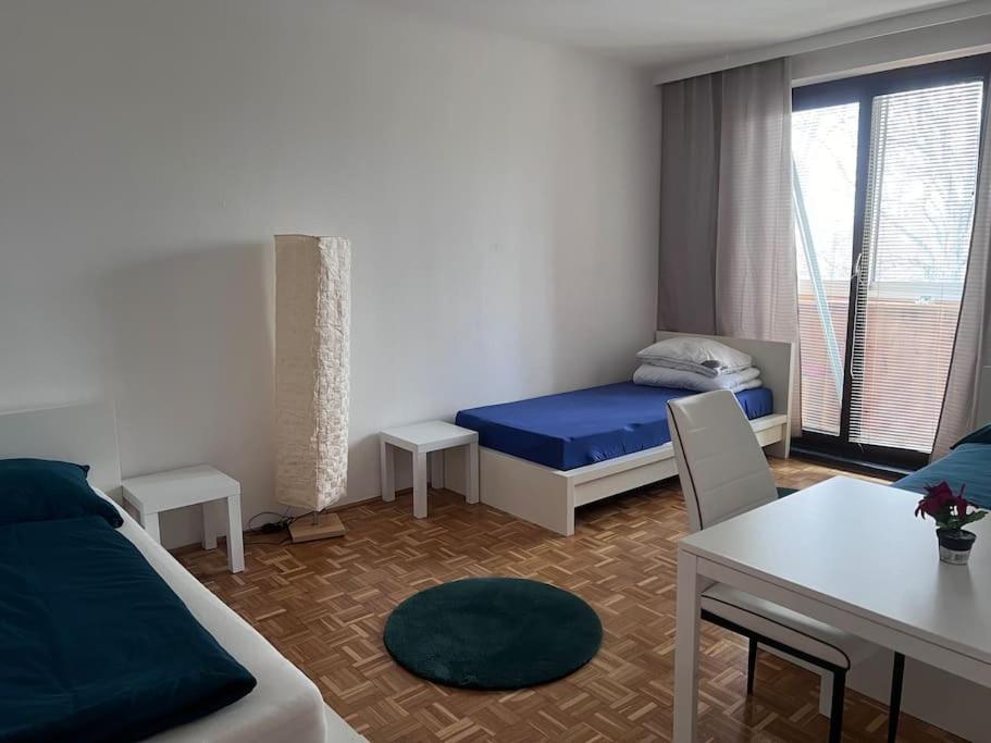Schlafzimmer mit einem Bett, einem Schreibtisch und einem Tisch in der Unterkunft Ruhige Wohnung in Schwechat nähe Flughafen in Schwechat