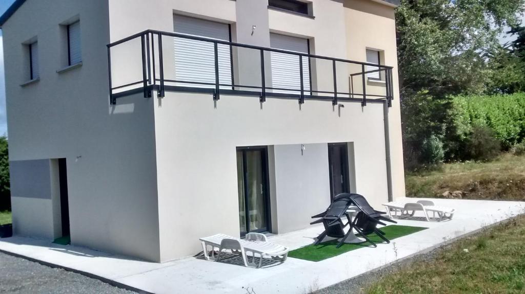 - un bâtiment avec deux bancs et un balcon dans l'établissement Gite Jours tranquilles, à Pleumeur-Bodou