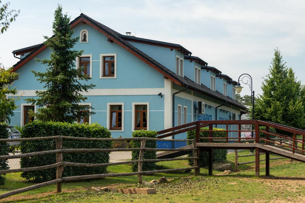 uma casa azul com uma cerca em frente em Hospůdka na Haldě em Boršice