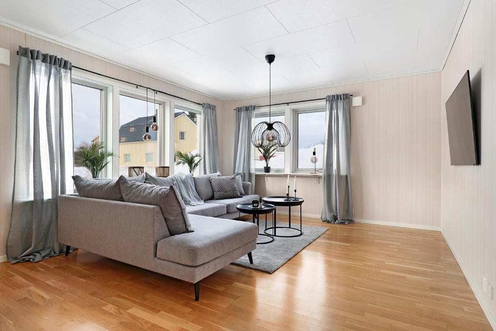 sala de estar con sofá y algunas ventanas en Guestly Homes - Homely 2BR Apartment with 3 Beds en Boden