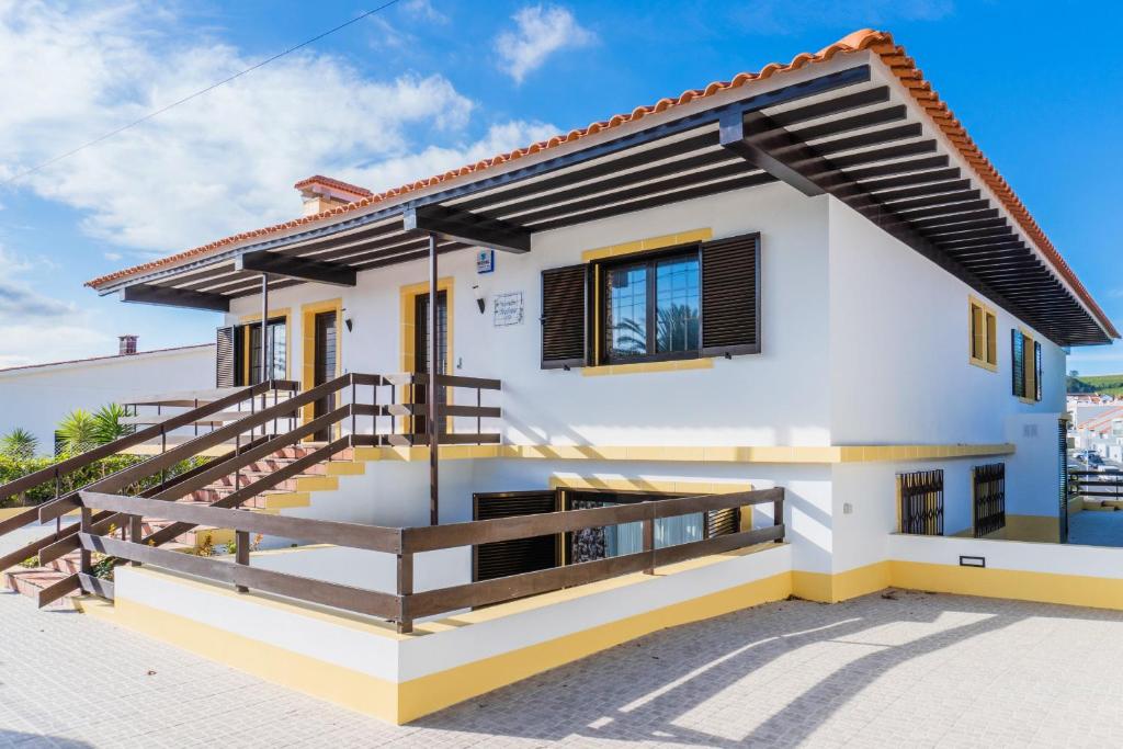 a white house with a balcony with a staircase at Pinheiro SUN&BEACH House in Ponta Delgada