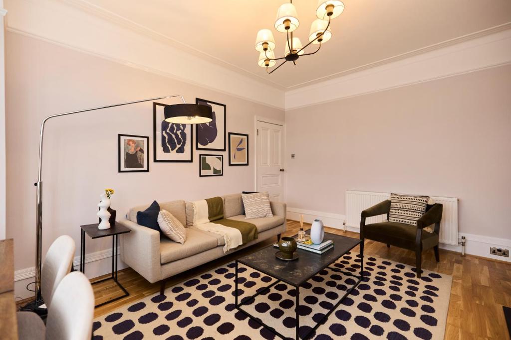 een woonkamer met een bank en een stoel bij The Cranley Gardens Escape - Spacious 2BDR Flat in Palmers Green