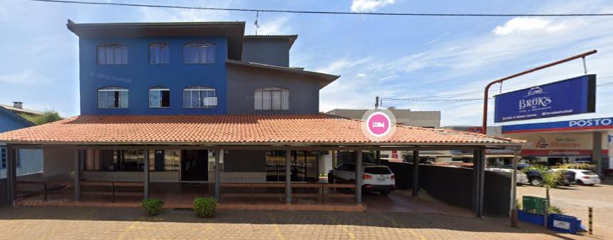 un edificio azul con un cartel delante en BROKS Hotel e Restaurante en Fraiburgo