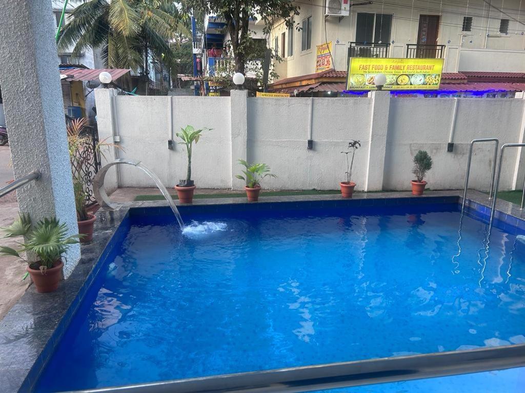 a large blue swimming pool with a water fountain at Calangute Beach Empire in Calangute