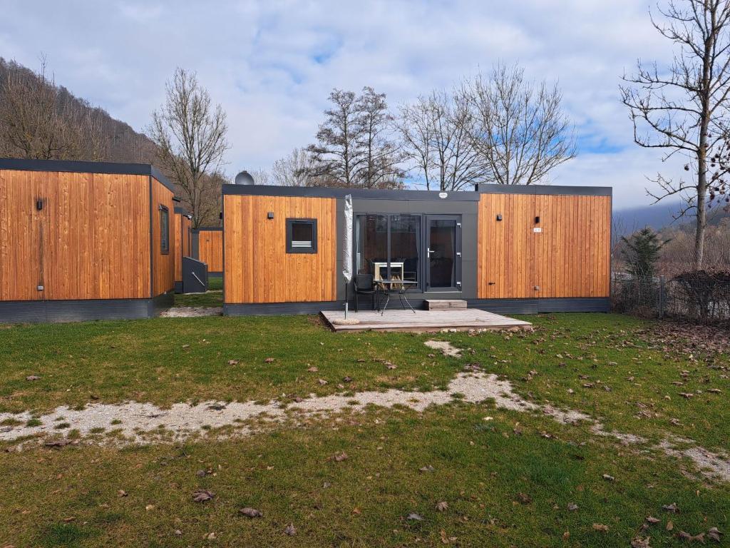 a house with wooden walls and a yard at Holiday Home Tiny Haus Altmühlblick III by Interhome in Riedenburg