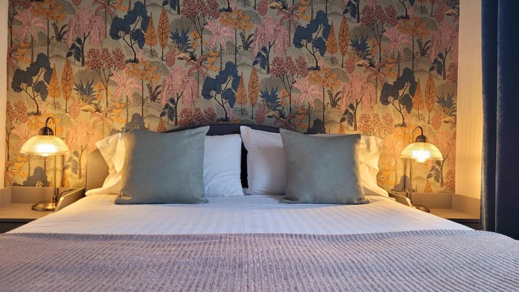 a bedroom with a bed with a floral wallpaper at The Commercial in St Just