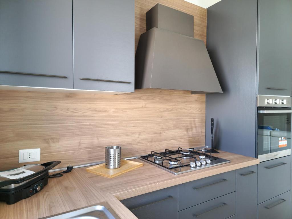 Il comprend une cuisine équipée d'une cuisinière. four supérieur à côté d'un comptoir dans l'établissement Villa Lu Tizzoni, à Budoni