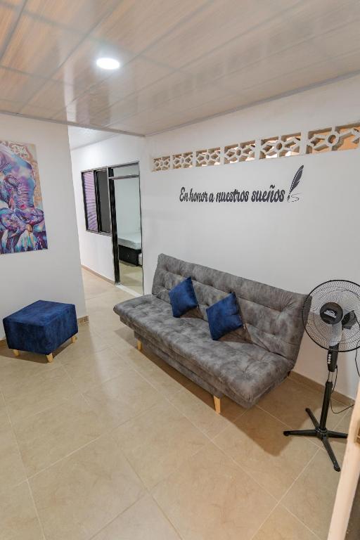 a living room with a couch and blue pillows at Denier House Guabinal - Cerca de Centros Comerciales in Ibagué