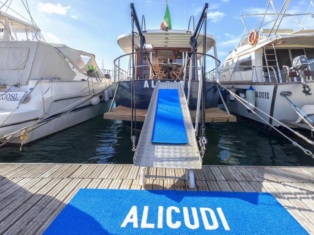 アルゲーロにあるHoliday Home Alicudi by Interhomeの2隻の船の隣にある青いランプのある桟橋