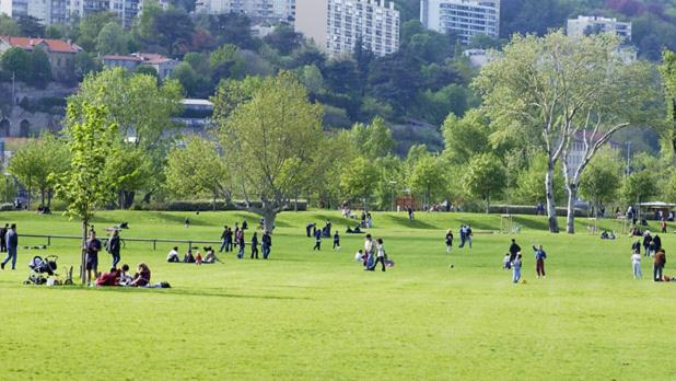a group of people sitting in a field in a park at Lionne-Stade du Lou in Lyon