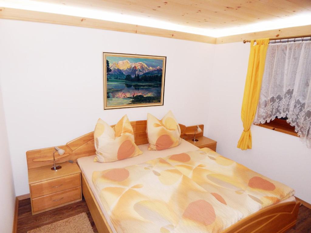 a bedroom with a bed and a painting on the wall at Chalet Ramsau in Ramsau