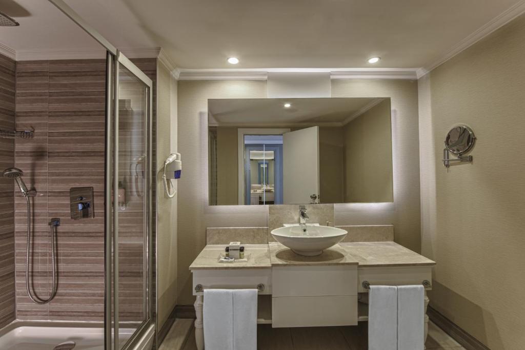 a bathroom with a sink and a shower at Delphin Imperial Lara in Lara
