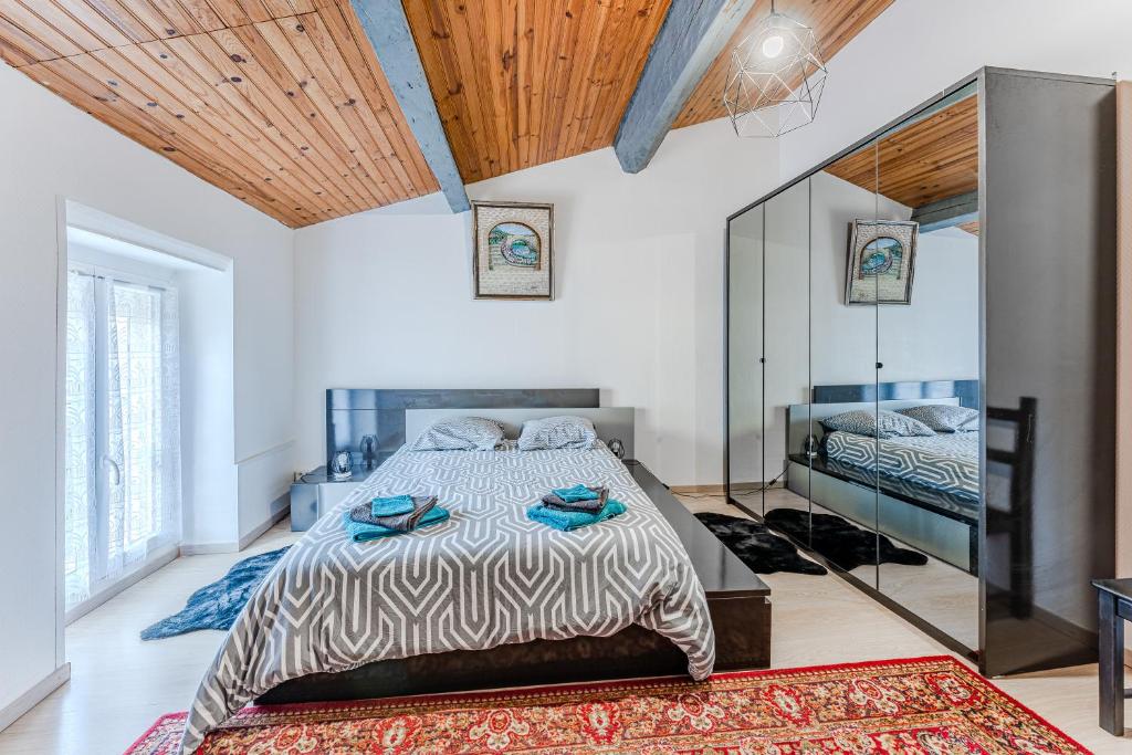 sypialnia z dużym łóżkiem i lustrem w obiekcie Chez Lea w mieście Saint-Seurin-de-Cadourne