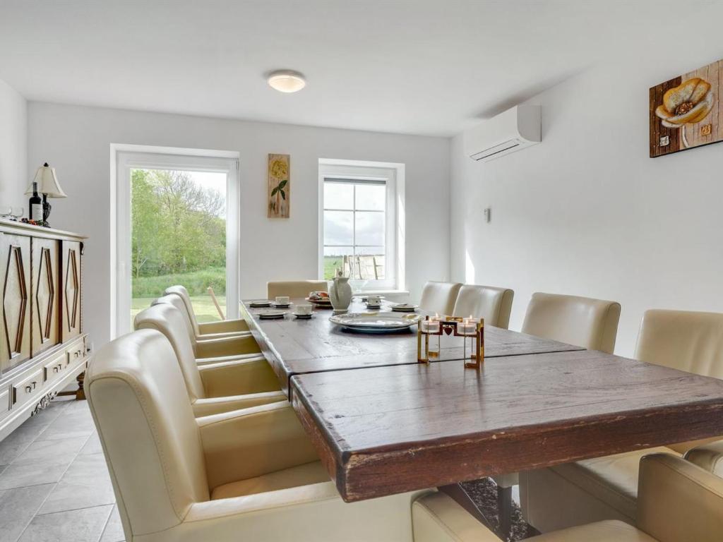 a dining room with a wooden table and chairs at Holiday Home Aliza - 14km from the sea in Western Jutland by Interhome in Bredebro