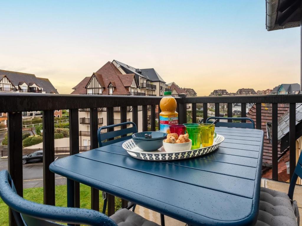 une table bleue avec un plateau de nourriture sur un balcon dans l'établissement Apartment Fleur Marine-34 by Interhome, à Cabourg