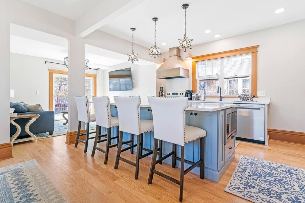 a kitchen with a bar with white bar stools at Memory Maker House - Built for families and kid ready in Cedar Falls