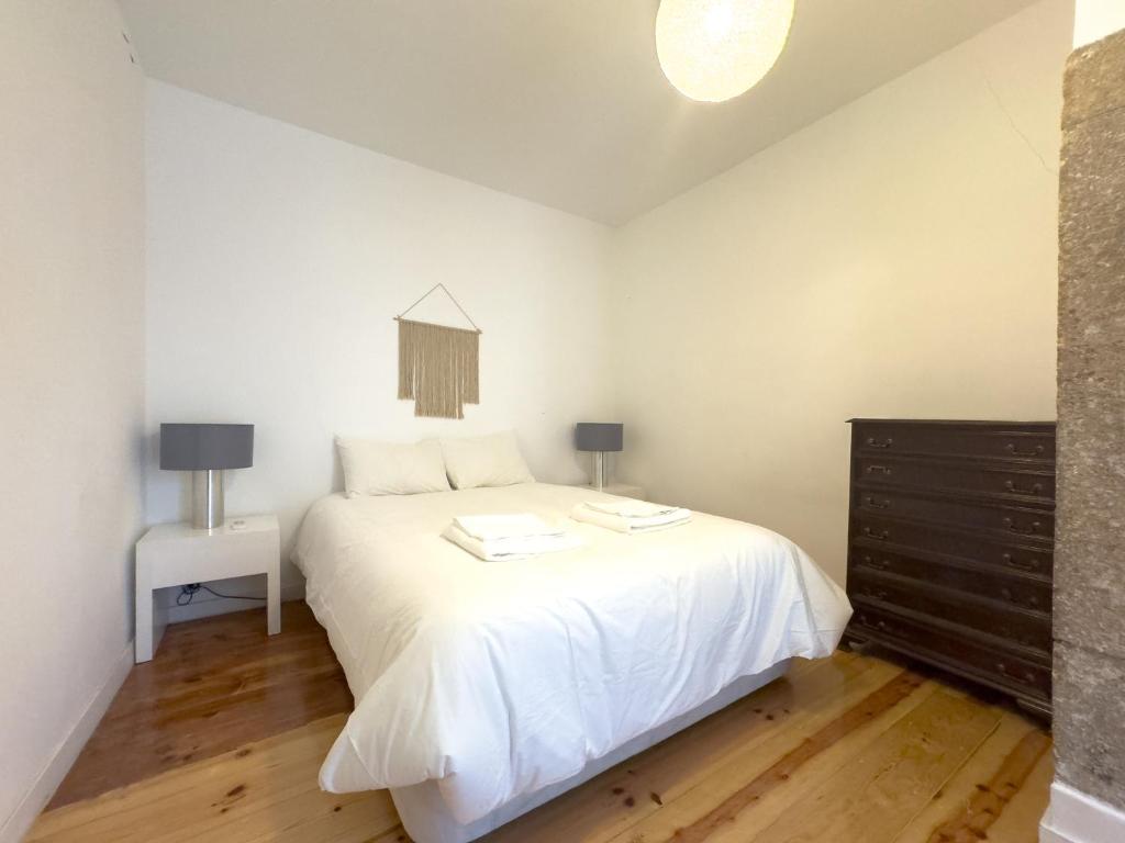 a bedroom with a white bed and a dresser at Home Mais 36 in Lisbon