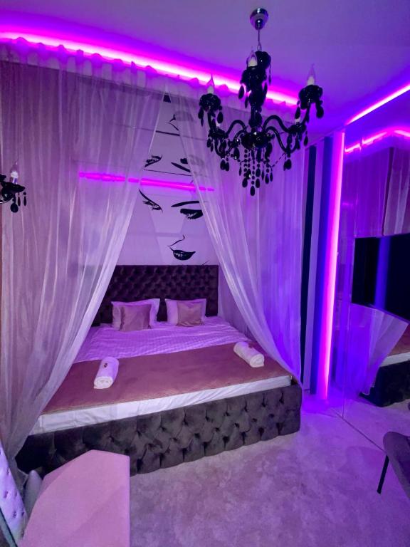a bedroom with a bed with pink lighting at Mystik Penthouse in Sighişoara