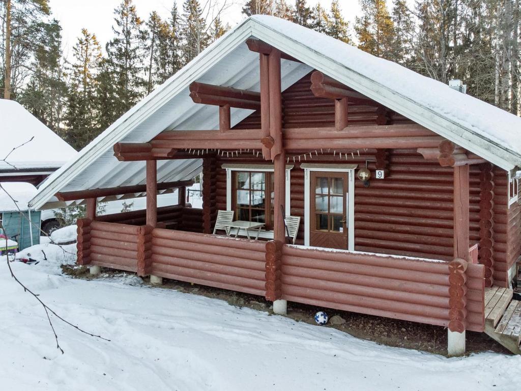 a log cabin with snow on the roof at Holiday Home Rustholli 9 by Interhome in Tampere