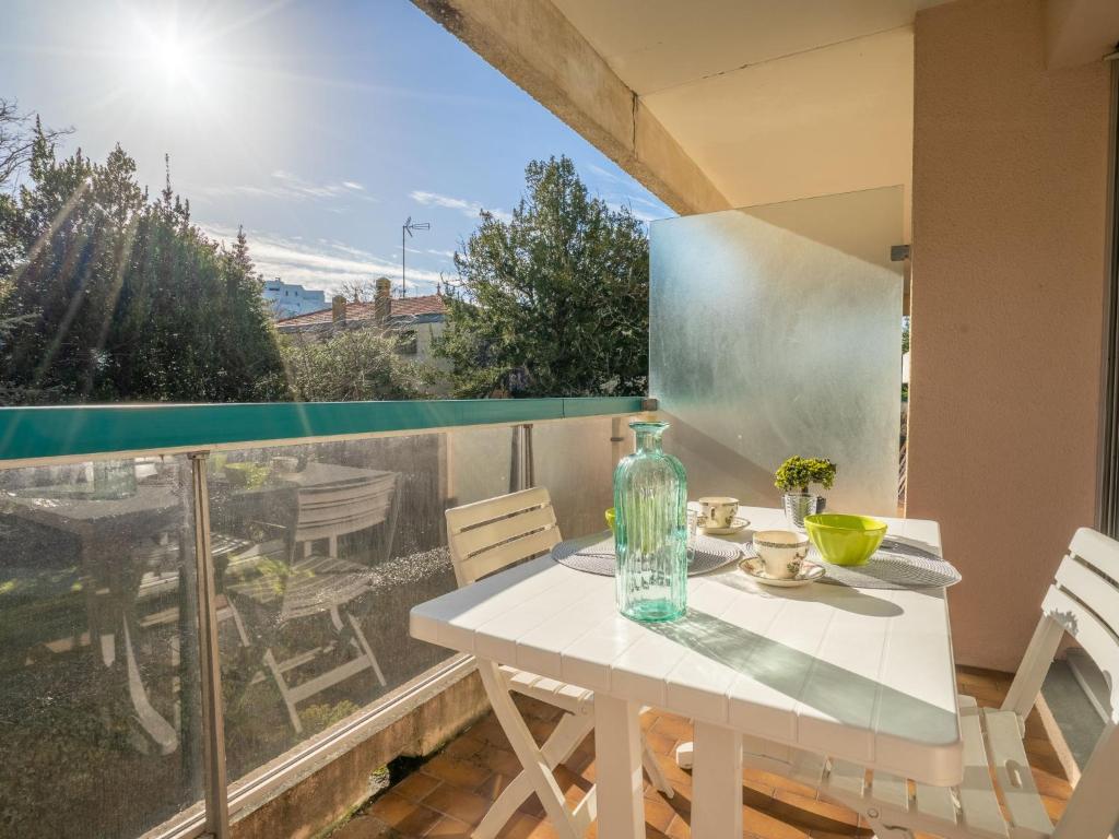 Biały stół i krzesła na balkonie z oknem w obiekcie Studio Eugénie-4 by Interhome w Arcachon