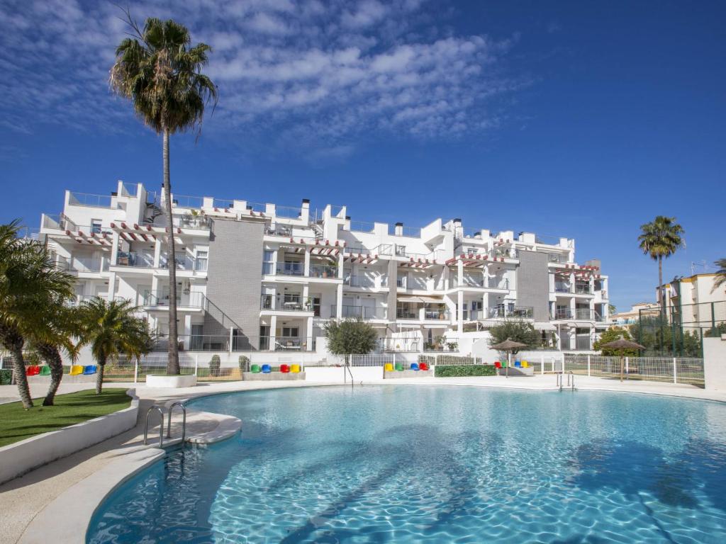 um grande edifício de apartamentos branco com uma grande piscina em Apartment Victoria Playa III Plus by Interhome em Denia